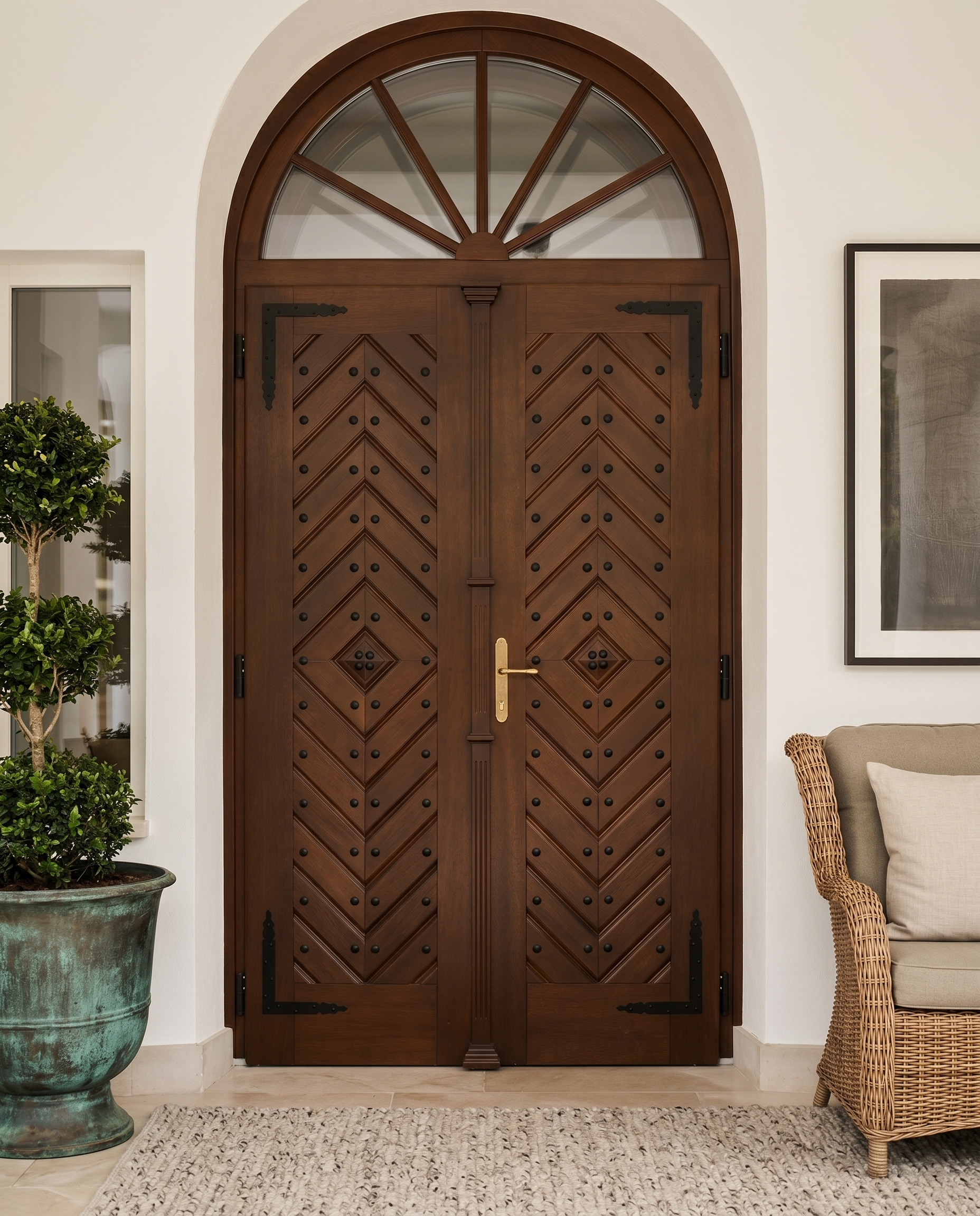 Custom arched double doors with diamond-pattern panelling and forged hardware in a residential entryway.