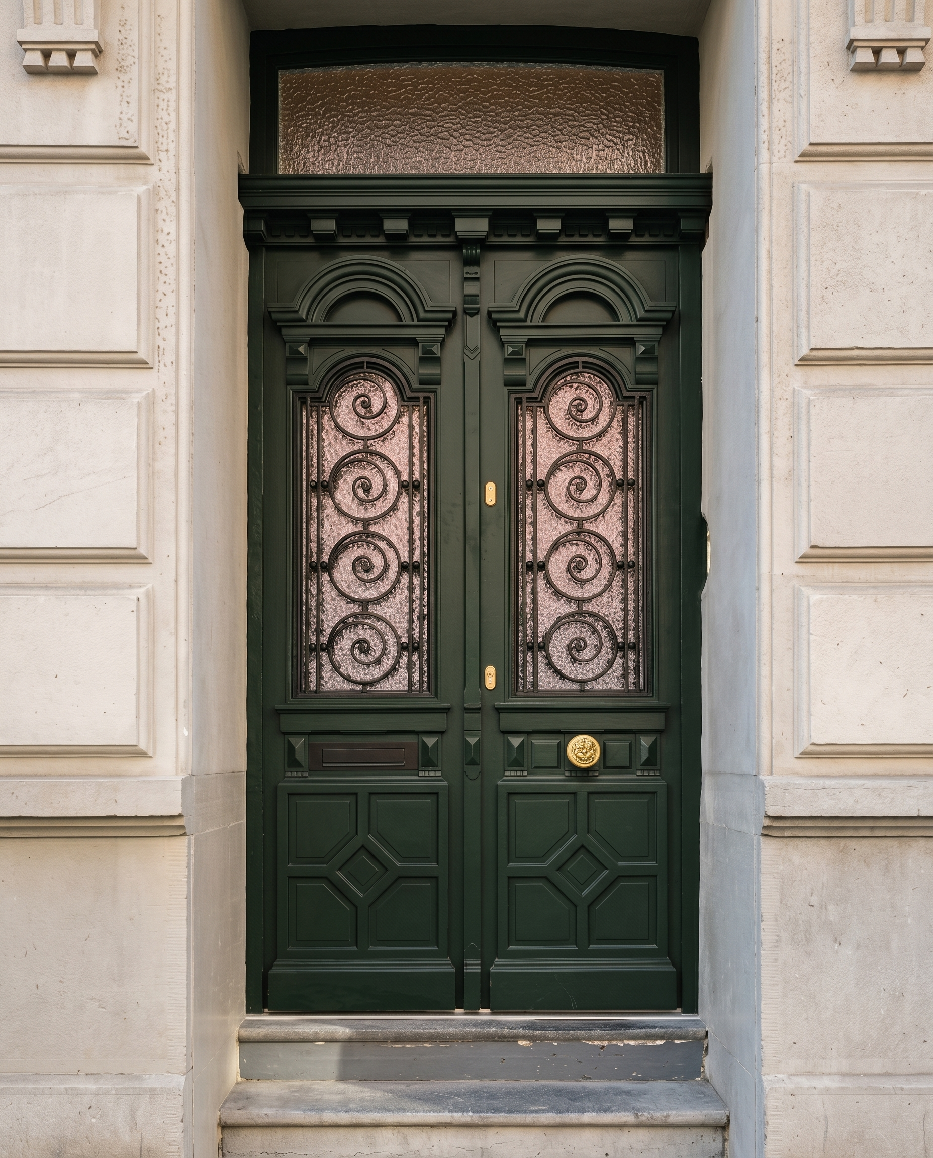 Heritage green double doors with ornate ironwork glazing on a classical facade.